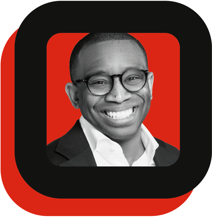 Headshot of a man wearing round frame glasses in a red and black themed frame