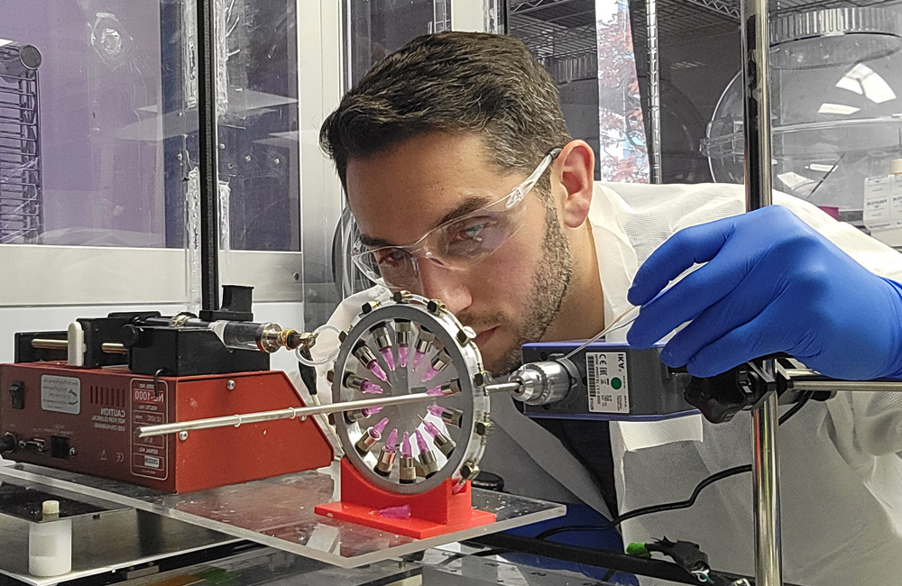 A male scientist holds a pipette as he focuses on his work in a laboratory.