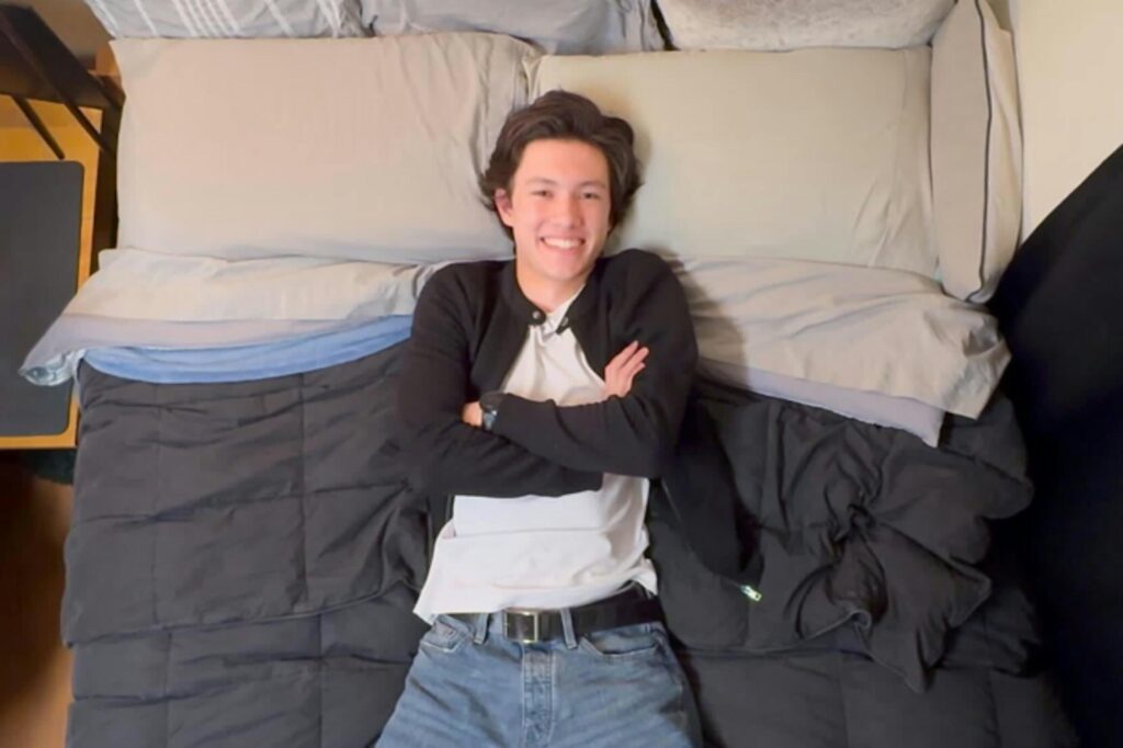man lying on a bed with arms crossed