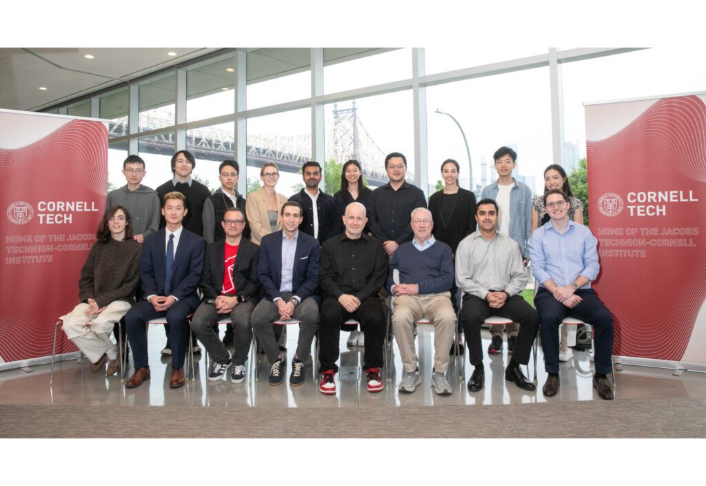 Group of people sitting between two Cornell Tech vertical banners