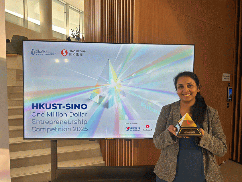 woman standing in front of tv monitor holding pyramid award