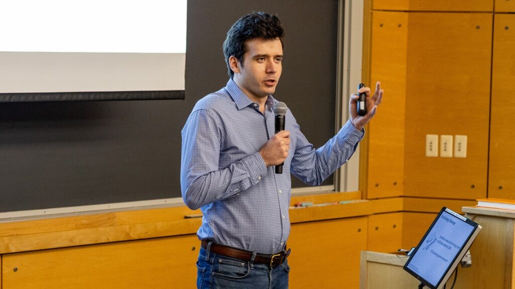 A man holding a microphone in one hand and a small device in another