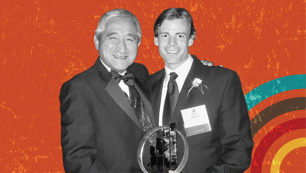two men standing in tuxedos holding an award in black and white tone, red background with colorful circles in lower right corner