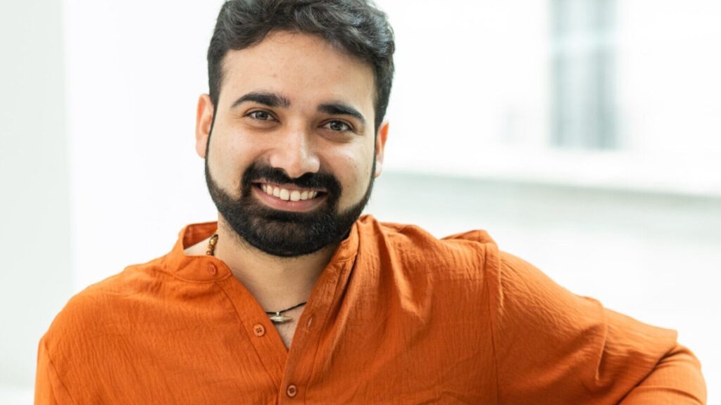 man smiling wearing an orange shirt