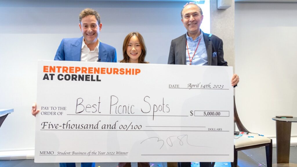 Student Business of the Year winner holding award check with Cornell Entrepreneur of the Year, Barry Beck and Cornell Alum