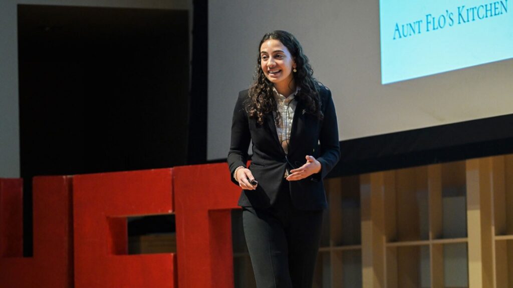Woman in suit speaking on stage