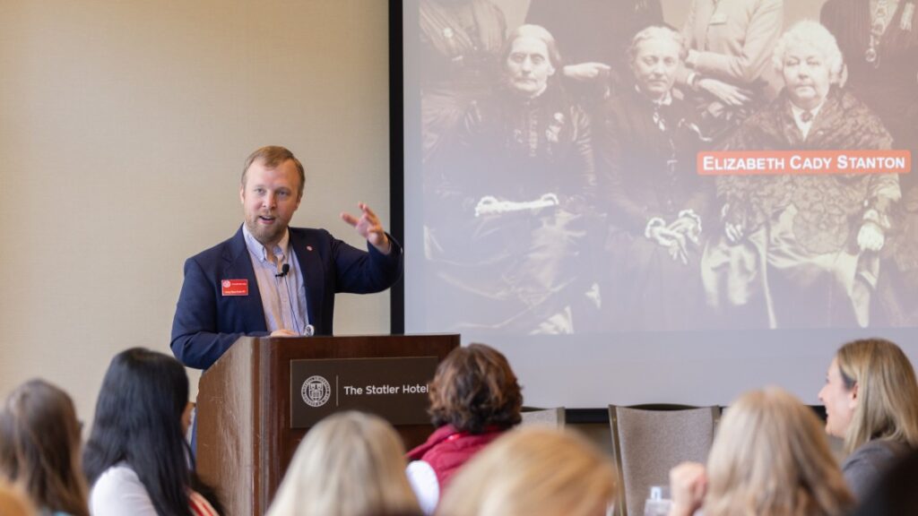 man speaking at a podium to an audience