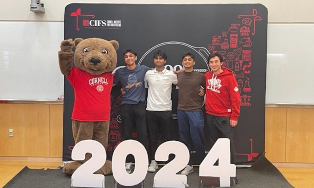 students and bear mascot standing in front of 2024 block numbers