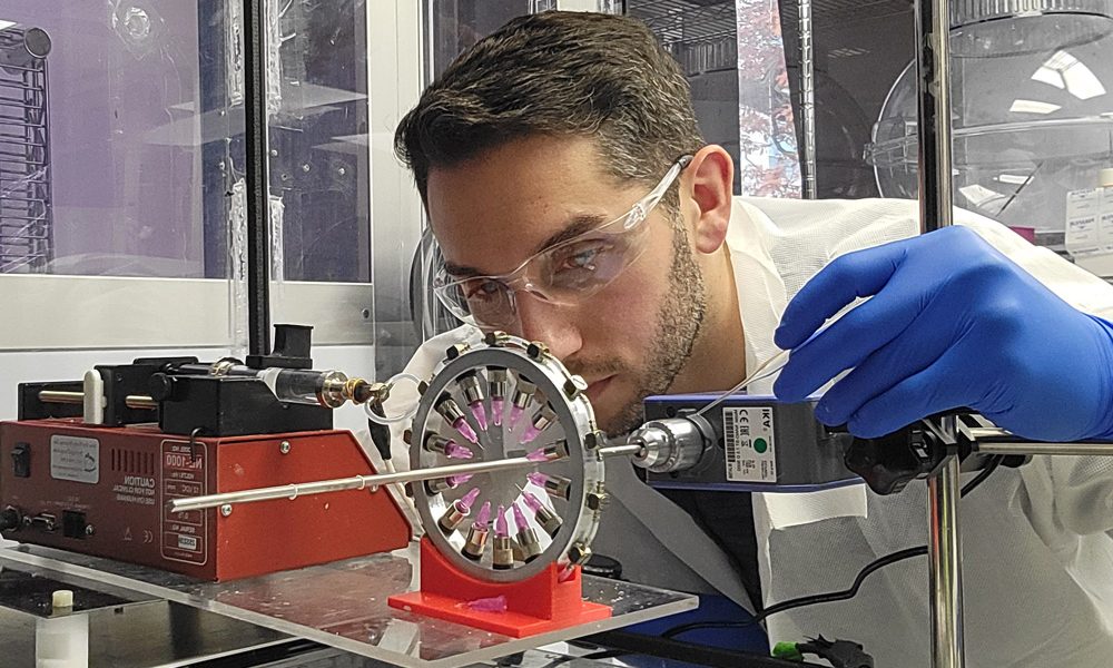 A male scientist holds a pipette as he focuses on his work in a laboratory.