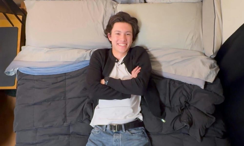 man lying on a bed with arms crossed
