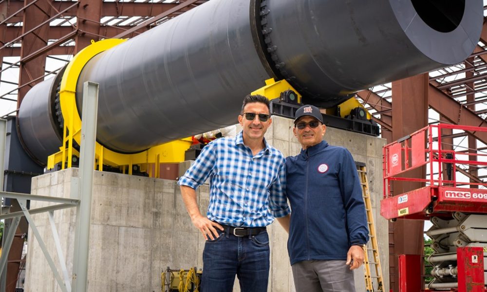 Two men standing in a power plant facility, both wearing sunglasses.