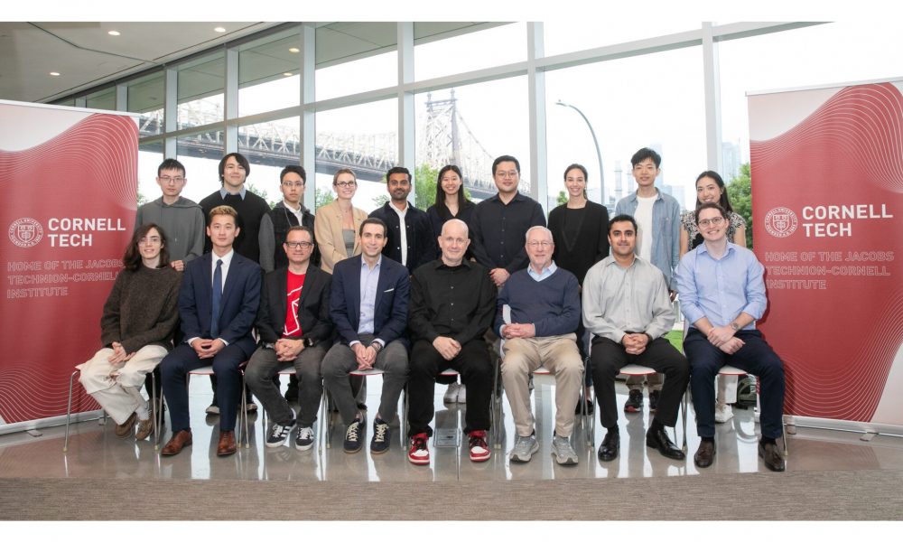 Group of people sitting between two Cornell Tech vertical banners