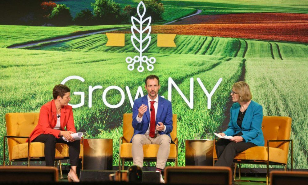 three people sitting on stage at GrowNY event