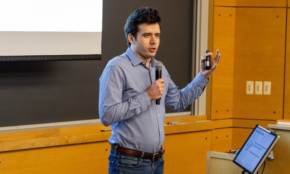 A man holding a microphone in one hand and a small device in another