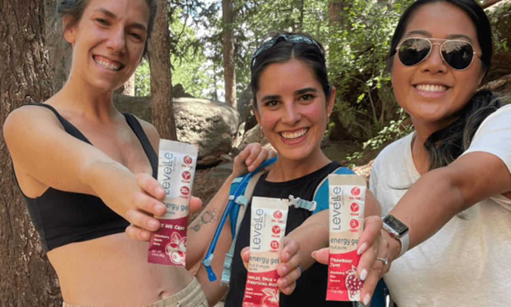 A group of women in athletic clothing hold up Levelle Nutrition energy gels.