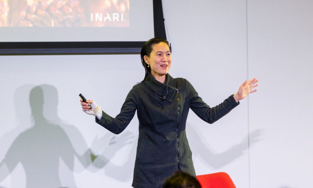 Woman dressed in black with arms raised