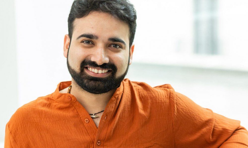 man smiling wearing an orange shirt