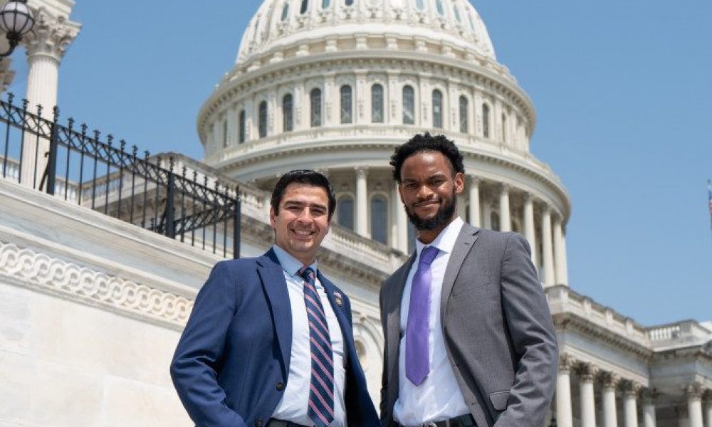 two men standing outside of capital building on steps