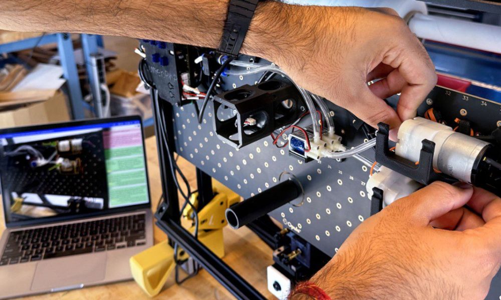arms and hands working on a circuit board
