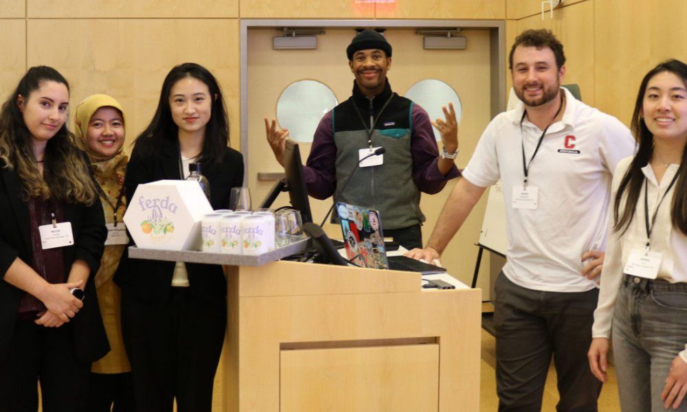 Winning team of students standing in front of podium