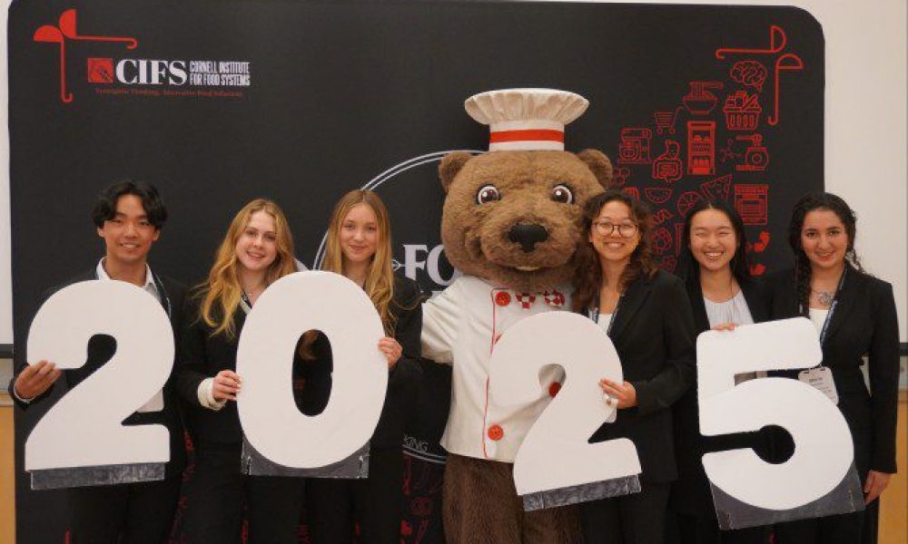 people holding 2 0 2 5 numbers and a bear dressed up as a chef