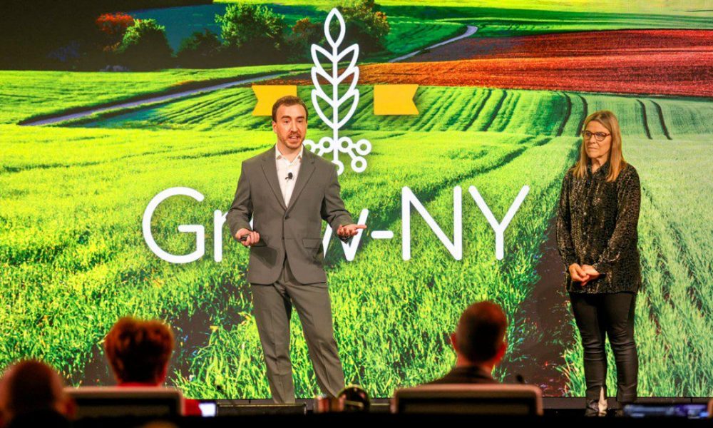 man and woman on stage with grow NY logo background