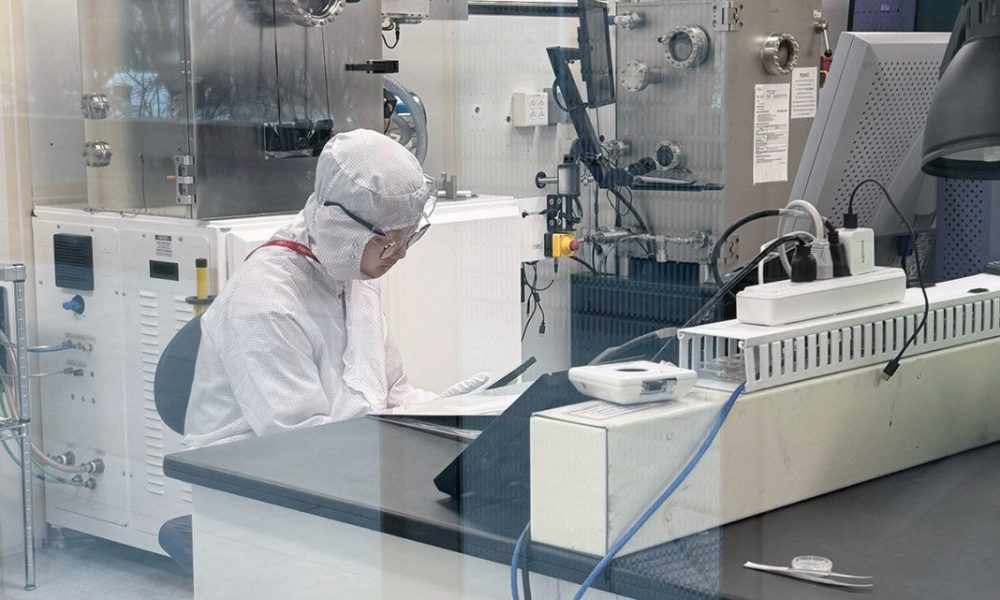 Person working in a lab wearing white personal protection equipment