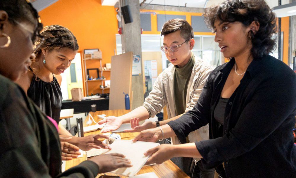 Members of the EquiPad team Bryan Wong, center right, and Sanjana Gurram, right, discuss their prototype with fellow entrepreneurs.