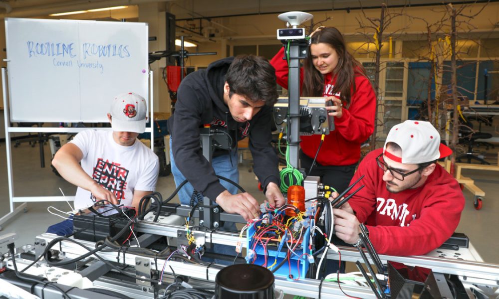 four people working together on an electronical device