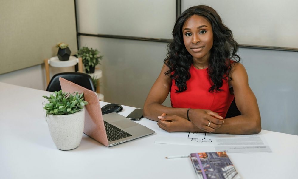 woman sitting at a table with laptop computer open