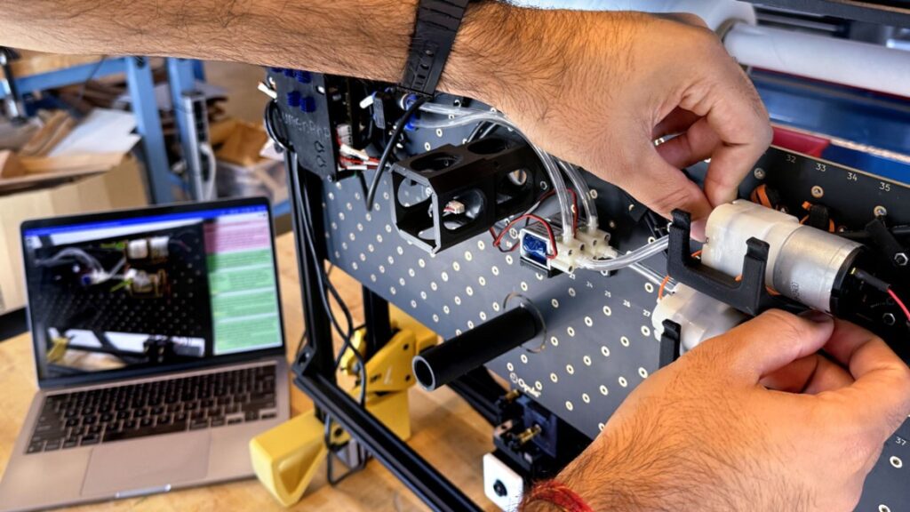 arms and hands working on a circuit board