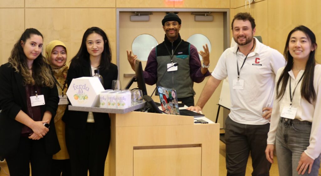 Winning team of students standing in front of podium