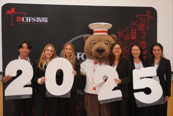 people holding 2 0 2 5 numbers and a bear dressed up as a chef