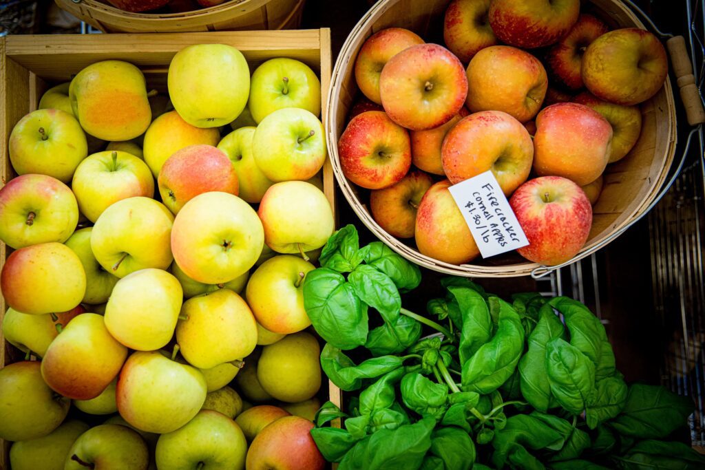 apples and basil in produce crates